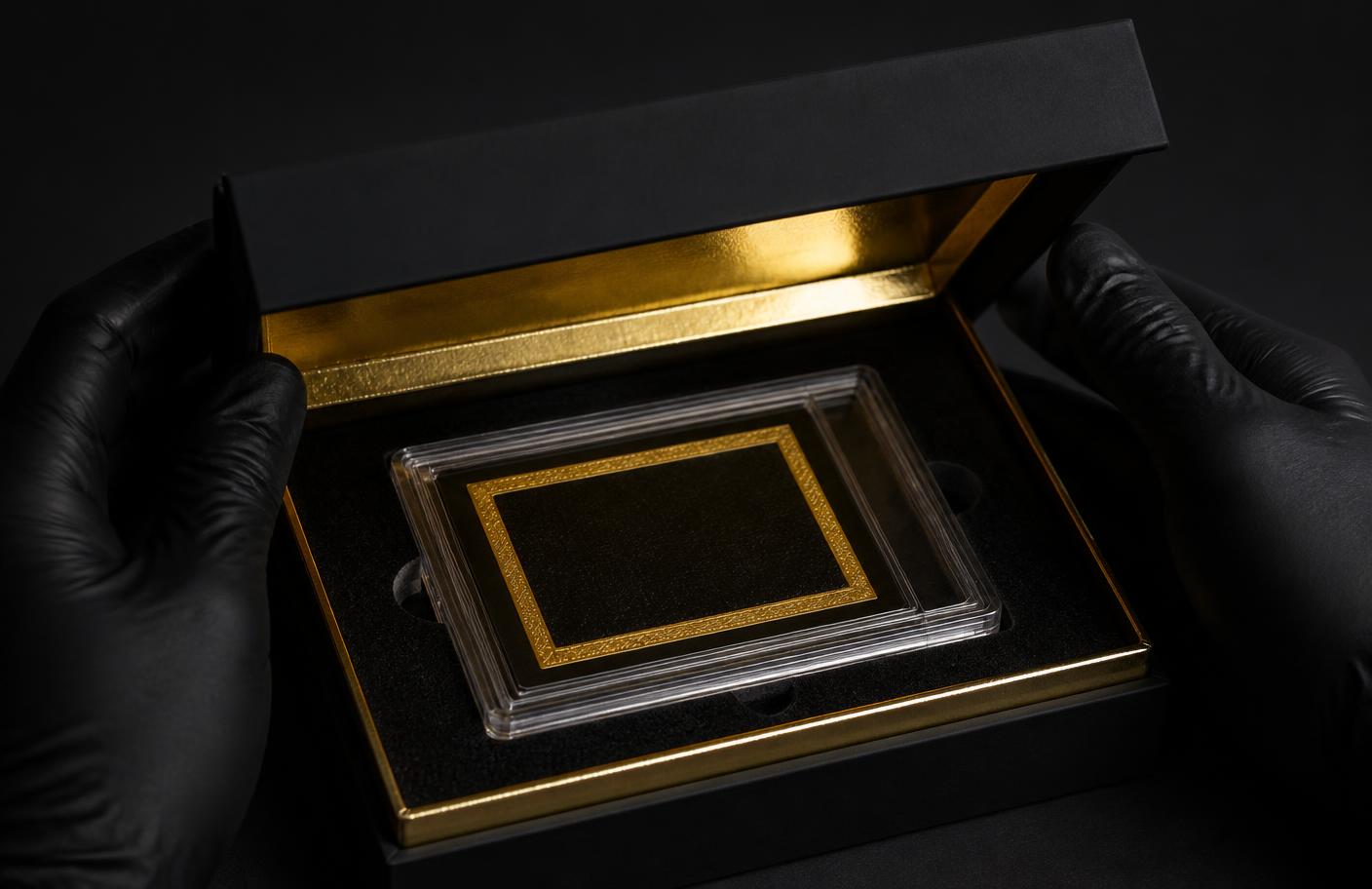 Gloved hands carefully handling a trading card by the edges over a soft mat